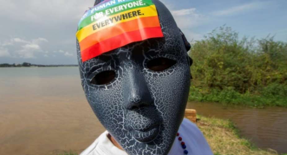 A Ugandan wearing a mask with a rainbow sticker takes part in the Gay Pride parade in Entebbe in 2015.  By ISAAC KASAMANI AFP