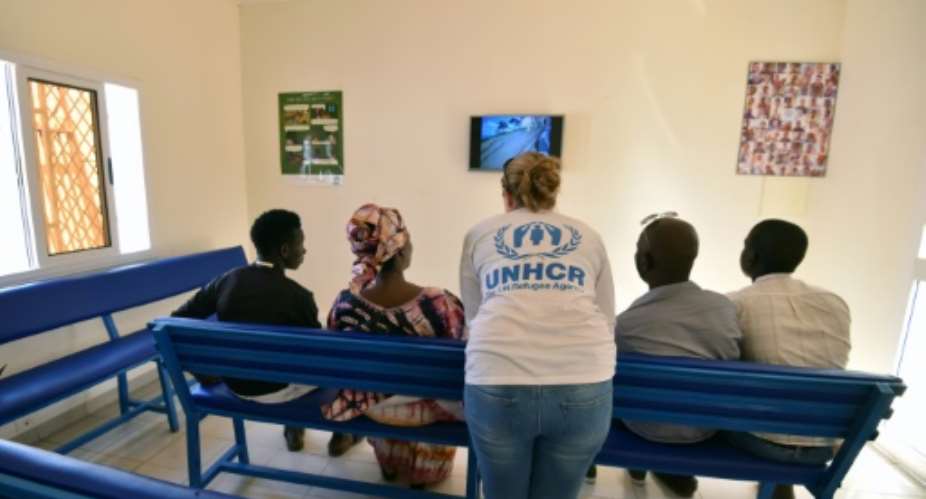 A UNHCR representative C speaks with refugees in November 2017.  By Sia KAMBOU AFPFile