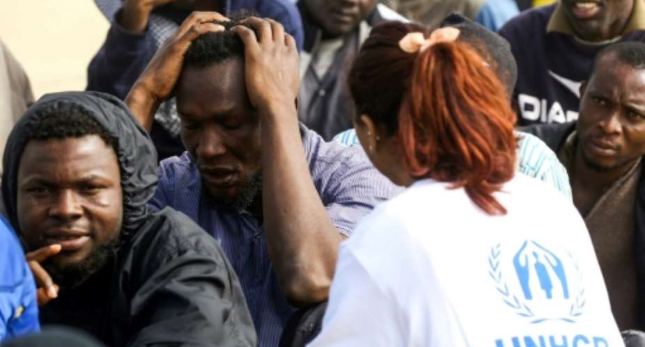 A UNHCR worker tends to African migrants in Libya pictured March 2018, where the UN refugee agency says reliable sources indicate that smugglers and traffickers pretend they work with that and other UN organisations to target refugees.  By MAHMUD TURKIA AFPFile