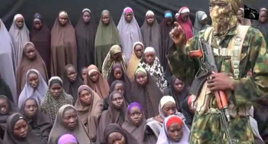A video grab image from a YouTube clip posted in August 2016, purportedly by Islamist group Boko Haram, shows what is claimed to be one of the group's fighters alongside kidnapped Chibok girls.  By HO AFPFile
