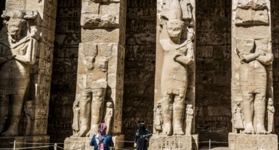 A visitor poses for a picture at the Mortuary Temple of Ramesses III in Medinet Habu, on the west bank of the Nile outside Egypt's southern city of Luxor.  By Khaled DESOUKI AFP