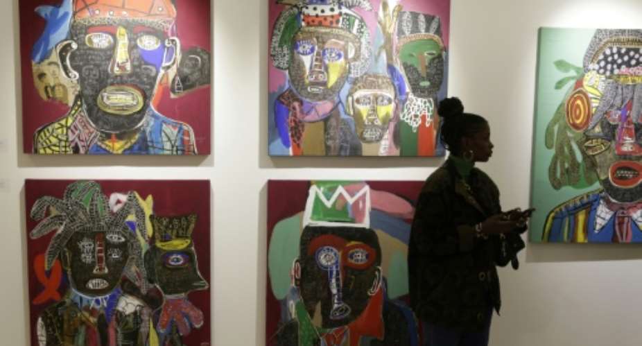 A visitor walks past artworks by Cameroonian artist Hako Hankson during the 1-54 Marrakesh Contemporary African Art Fair.  By Abdel Majid BZIOUAT (AFP)