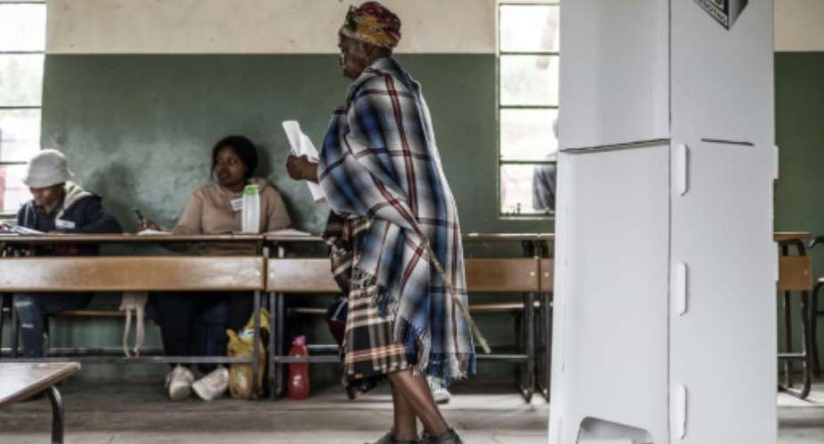 A voter leaves the polling booth, holding her ballot, in the town of Koro-Koro.  By MARCO LONGARI AFP