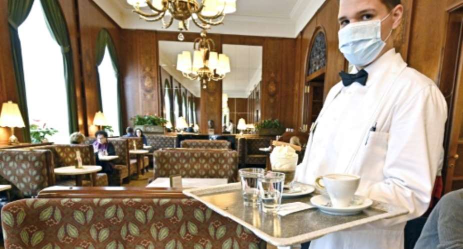A waiter wearing a mask at a newly reopened cafe in Vienna, as Austria lifts its coronavirus lockdown.  By HANS PUNZ APAAFP
