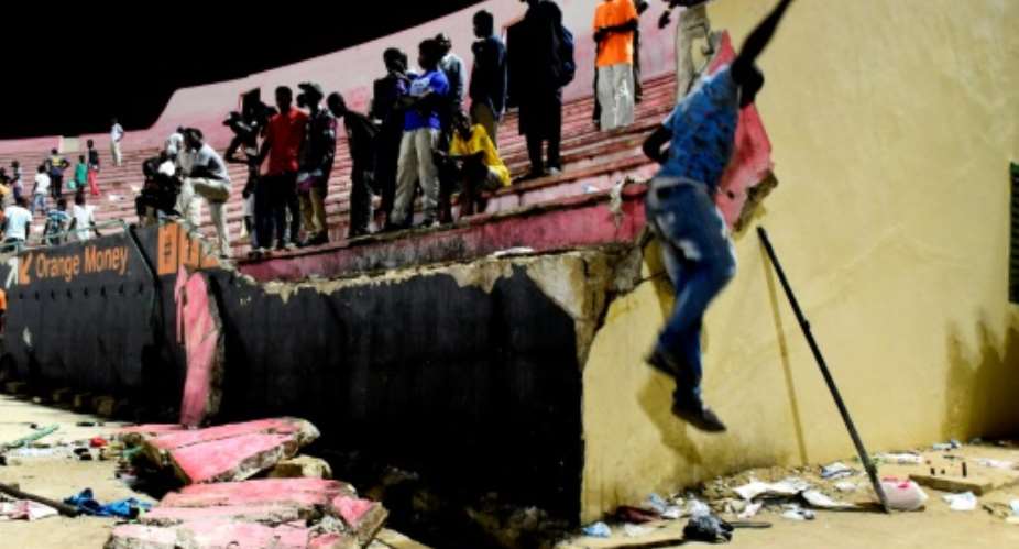 A wall collapsed onto fans fleeing the stadium to escape the hail of projectiles, with some crushed in the panic. Eight people died and dozens more were injured in the crush.  By SEYLLOU AFPFile