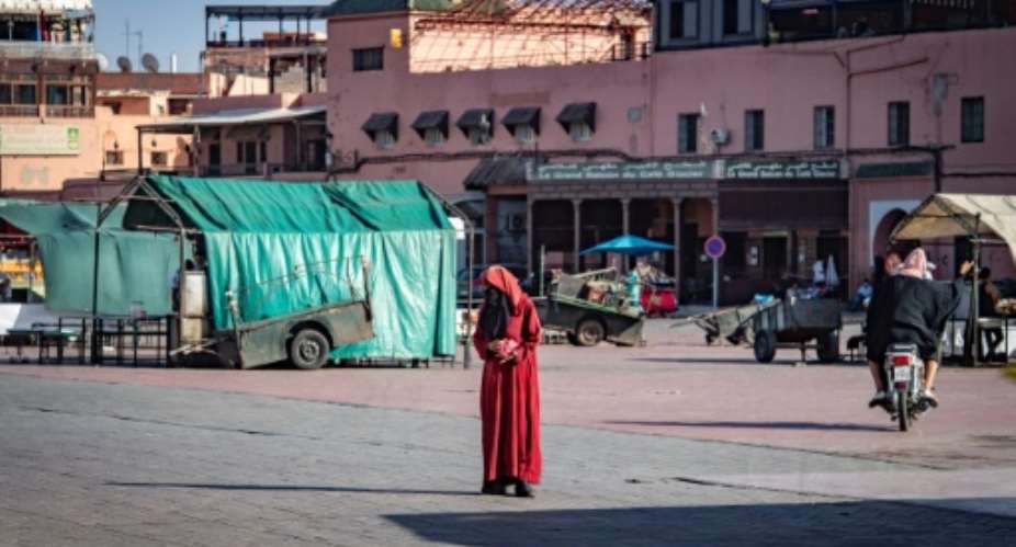 A woman crosses the legendary Jemaa el-Fna square in the Moroccan city of Marrakesh, currently empty of its usual crowds due to the Covid-19 pandemic.  By FADEL SENNA AFPFile