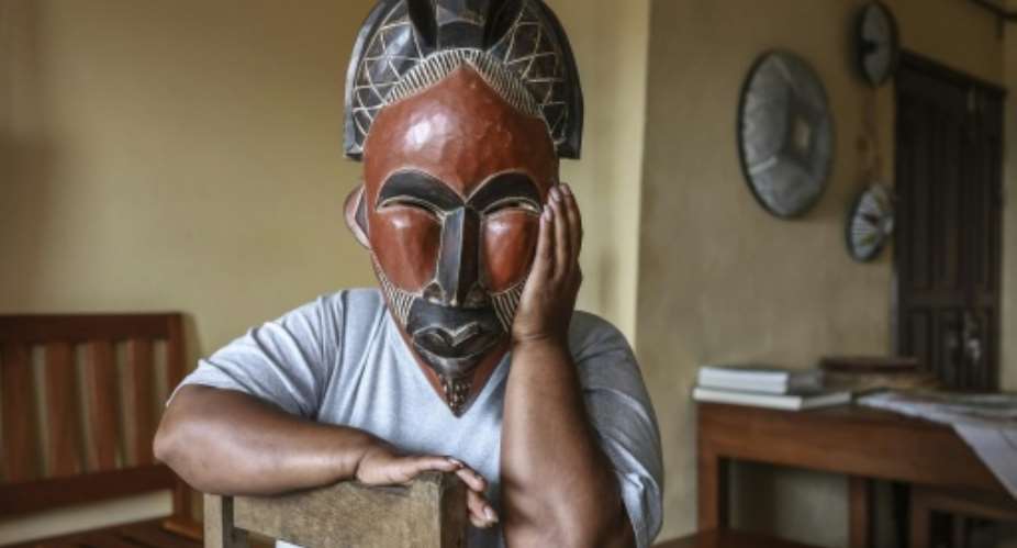 A woman deported from the US to Cameroon in an immigration crackdown shields her face with a mask as she poses for a photograph in Yaounde on September 9, 2026.  By - (AFP)