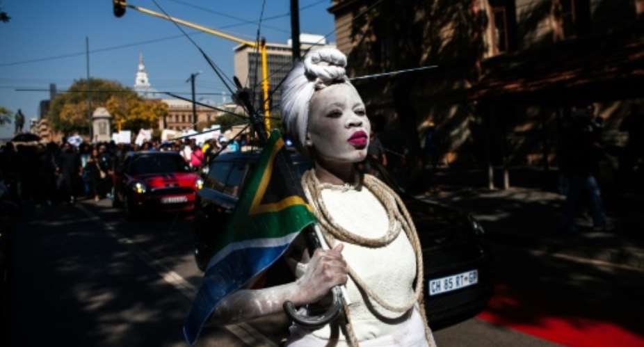 A woman dressed in a wedding gown and holding a South African flag leads a march in Pretoria against the abuse of women following the spike in reports of women being murdered and raped in various parts of the country.  By WIKUS DE WET AFP