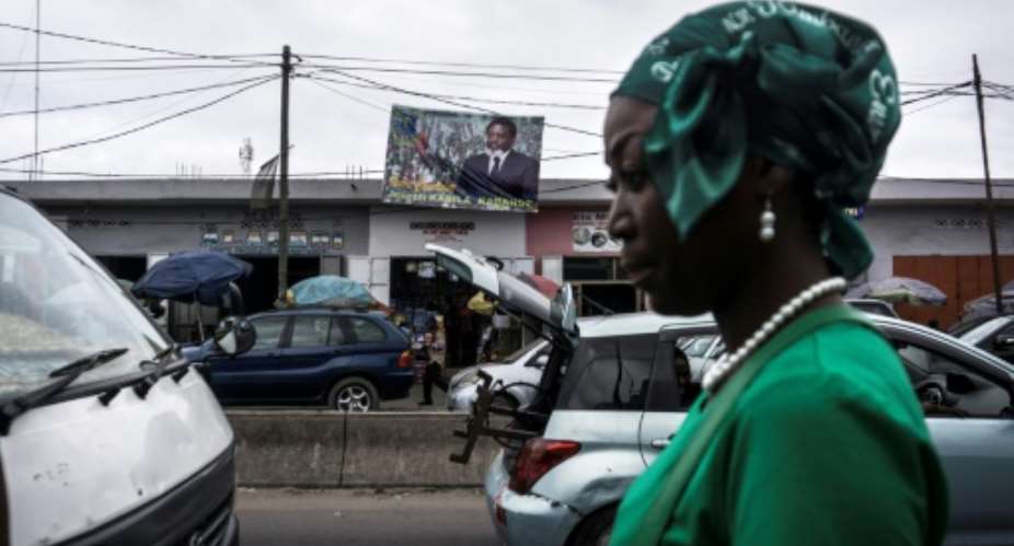 A woman in front of a campaign poster for DR Congo President Joseph Kabila in the capital Kinshasa in May.  By JOHN WESSELS AFPFile