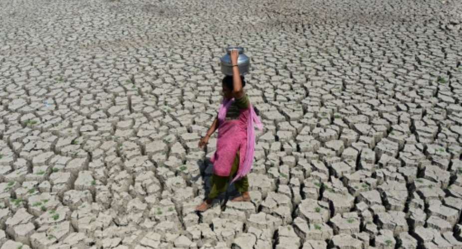 A woman searching for water walks on the parched bed of Chandola Lake, near the Indian city of Ahmedabad. A severe drought struck the region in 2016.  By SAM PANTHAKY AFPFile