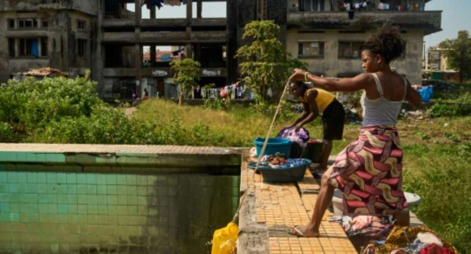 A woman uses a rope and a plastic container to get water from a pool at the Grande Hotel in Beira.  By Zinyange Auntony (AFP)