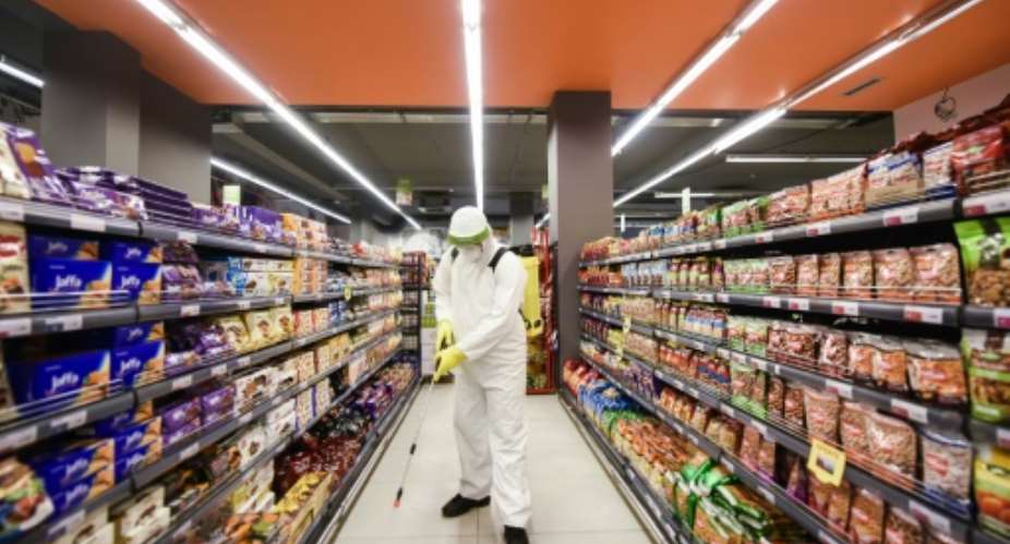 A worker disinfects the floor of a supermarket in Kosovo.  By Armend NIMANI AFP