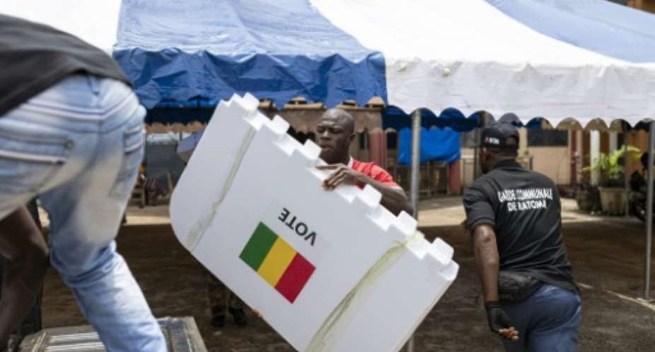 A worker loads voting booths into a pickup truck in Conakry on the eve of the countrys constitutional referendum.  By PATRICK MEINHARDT (AFP)