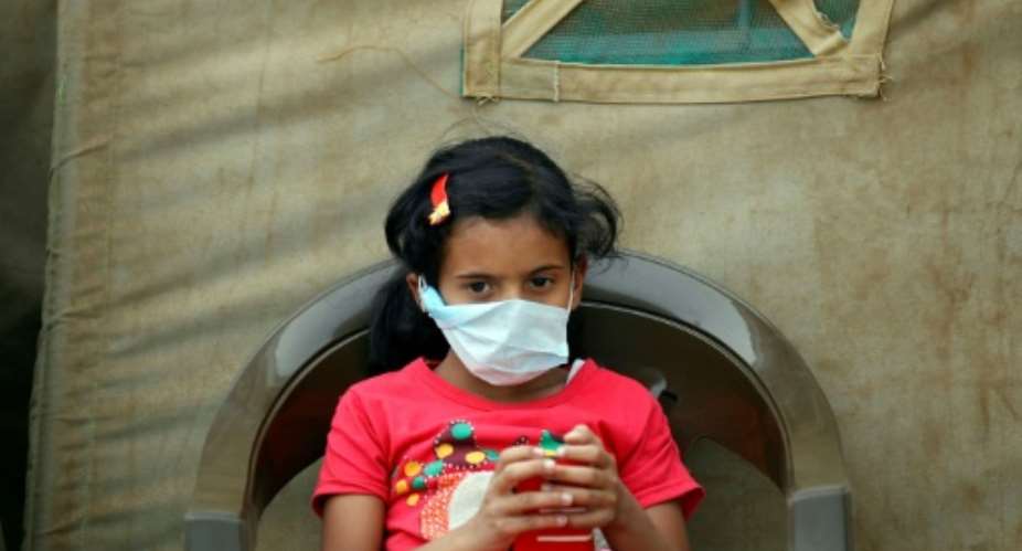 A Yemeni child suspected of being infected with cholera sits outside a makeshift hospital in Sanaa.  By  AFP