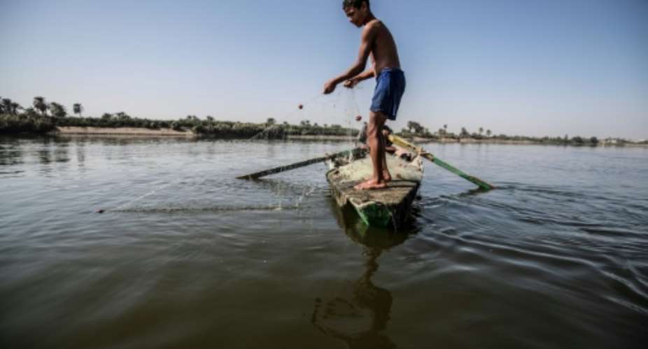 A young Egyptian fisherman pulls his net in the River Nile in a village near Minya, south of the capital Cairo.  By Khaled DESOUKI AFP