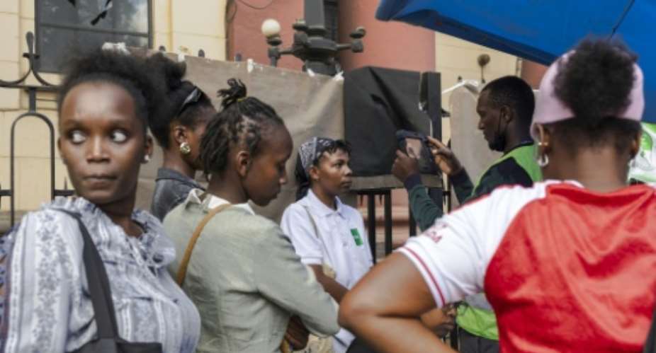 A young woman has her biometrics captured in a makeshift setup by officials using a biometric voter registrations kit.  By Tony KARUMBA (AFP)