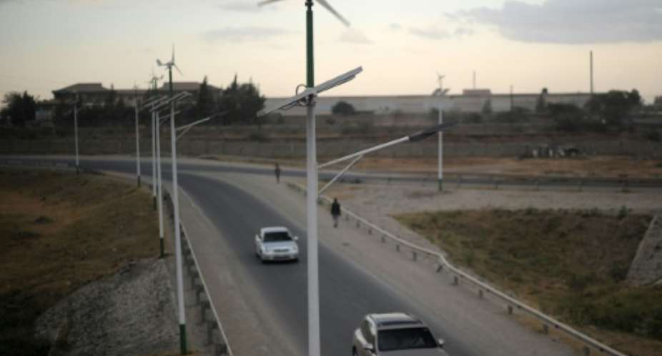 Street lamps powered by wind and solar energy line the side of a road leading from Athi-river town in Machakos county, approximately 25 kilometres from the Kenyan capital Nairobi, on August 19, 2015.  By Tony Karumba AFPFile