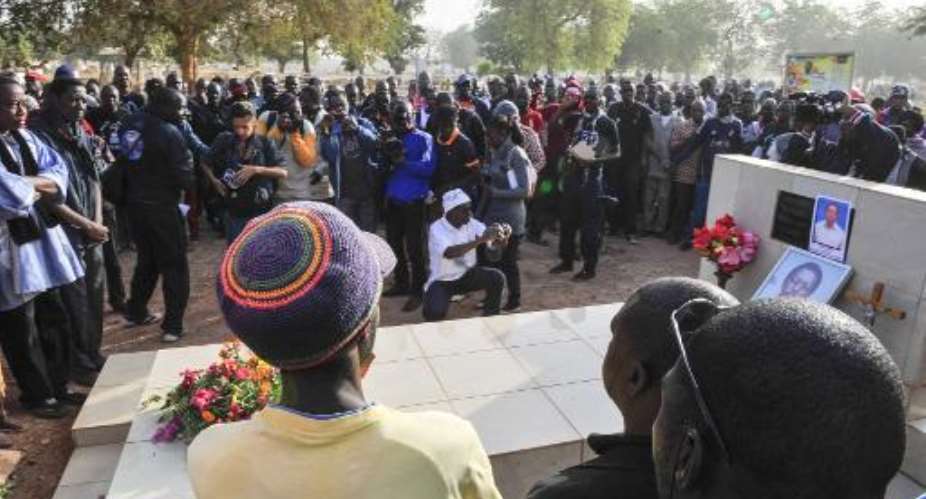 People, including relatives, gather around the grave of slain Burkinabe journalist Norbert Zongo on December 13, 2014 in Ouagadougou.  By Ouoba-Ahmed AFPFile