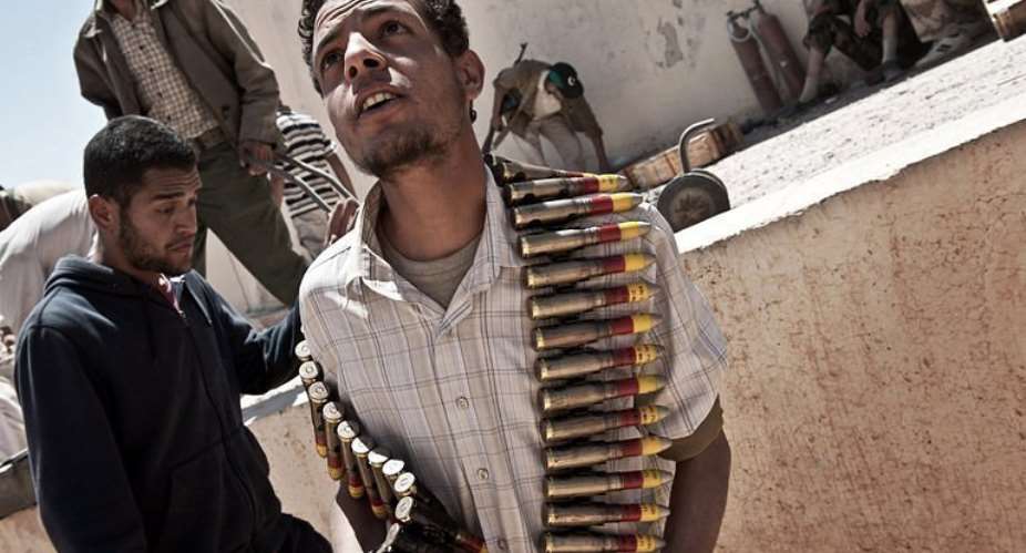 A Libyan rebel carries ammunition captured from a pro-Kadhafi weapons depot on the outskits of Zintan.  By Colin Summers (AFP)