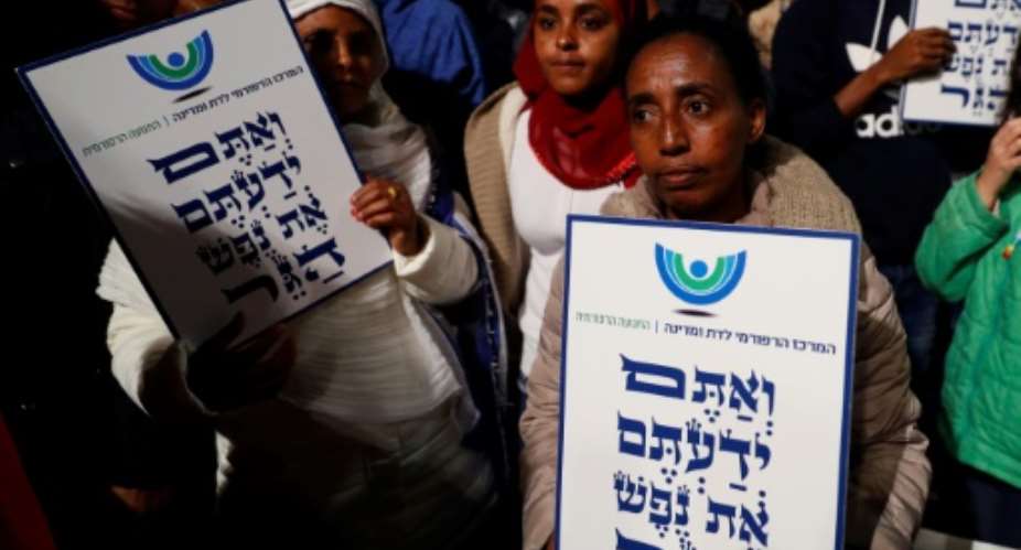 African migrants hold signs Hebrew signs: You come from the Bible, you too are refugees, during a demonstration in Tel Aviv on February 24, 2018, against the Israeli government's policy to forcibly deport African refugees and asylum seekers.  By JACK GUEZ AFPFile