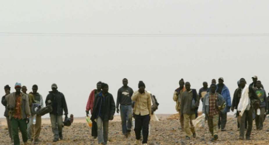 African migrants walk in the middle of the Sahara Desert on October 8, 2005.  By SAMUEL ARANDA AFPFile