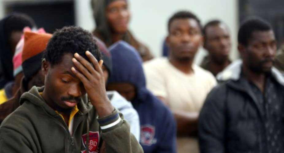 African migrants who were either rescued from the Mediterranean Sea or prevented from crossing to Europe by Libyan coast guards wait at a detention center in Zawiyah, 45 kilometres west of the Libyan capital, Tripoli.  By MAHMUD TURKIA AFP