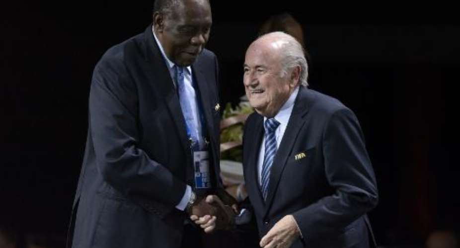 FIFA president Sepp Blatter R shakes hands with FIFA Executive member and president of the Confederation of African Football Issa Hayatou after being re-elected during the FIFA Congress in Zurich on May 29, 2015.  By Fabrice Coffrini AFP
