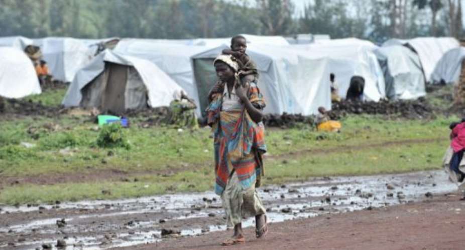 A woman walks with her child on October 15, 2012 in the Kanyaruchinya camp for internally displaced people, near Goma.  By Junior D. Kannah AFPFile