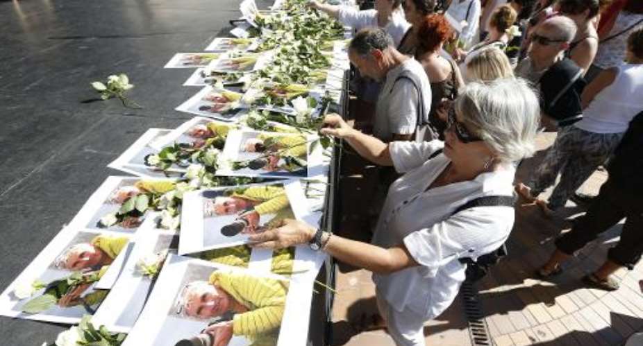People pay tribute to mountain-guide Herve Gourdel, who was beheaded by Jihadists linked to the Islamic State group in Algeria, during a gathering in Nice, southeastern France, on September 27, 2014.  By Valery Hache AFPFile