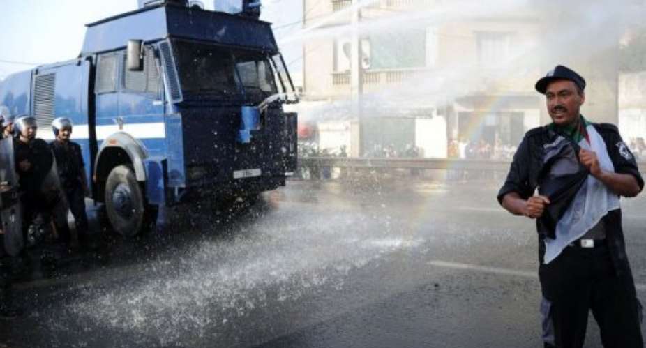 Algerian police auxiliaries are sprayed by a water cannon as they demonstrate to demand pay increases.  By Farouk Batiche (AFP)