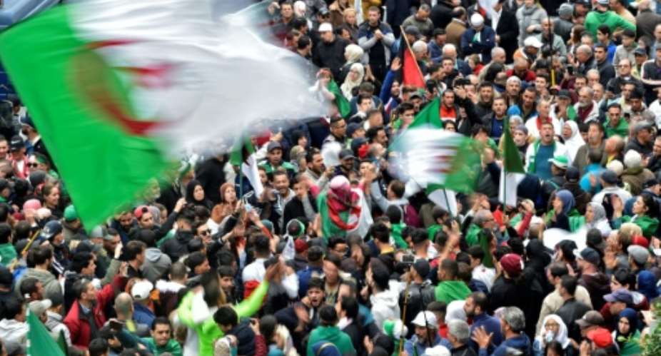 Algerian protesters wave national flags during an anti-government demonstration in the capital Algiers.  By RYAD KRAMDI AFP