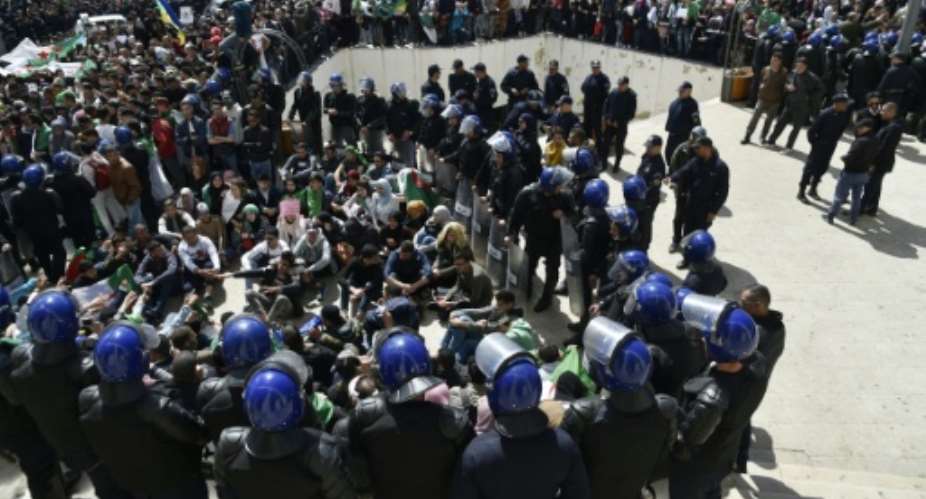 Algerian riot police come face to face with anti-government protesters in the capital Algiers.  By RYAD KRAMDI AFP
