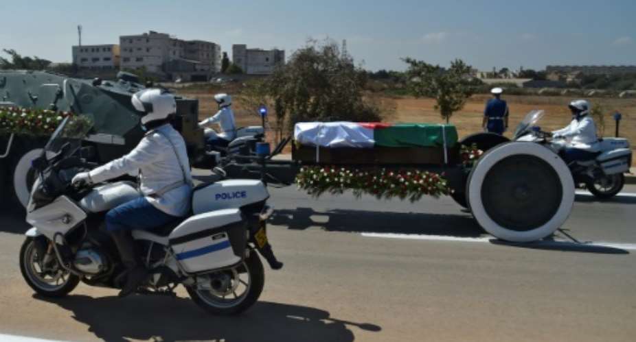 Algerian security forces escort the coffin of former president Abdelaziz Bouteflika to El-Alia cemetery in the capital Algiers on September 19, 2021.  By Ryad KRAMDI AFP