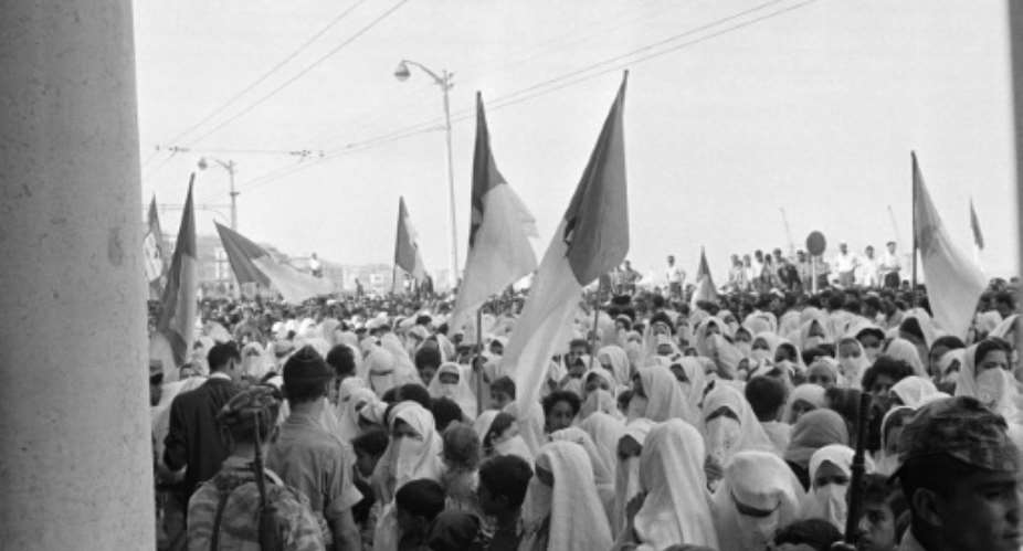 Algerian soldiers, veiled women and children, wave National Liberation Front (FLN) and now independent Algerian state flags on August 03, 1962.  By - (AFP)