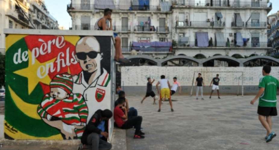 Algerians play football in Algiers Bab el-Oued neighbourhood, which is historically known to be a predominantly pro-Mouloudia Club Alger (MCA) area.  By Ryad Kramdi (AFP)