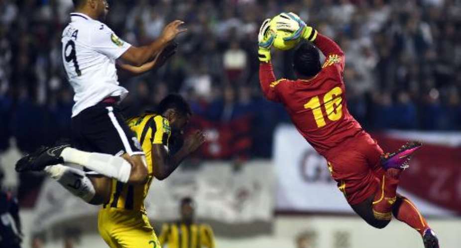Algerias ES Setifs Abdelmalek Ziaya (L) looks on as Congos AS Vitas goalkeeper Lukong Bongaman catches the ball during the Confederation of African Football Champions League final betweent in Blida on Novermber 1, 2014.  By Farouk Batiche (AFP)