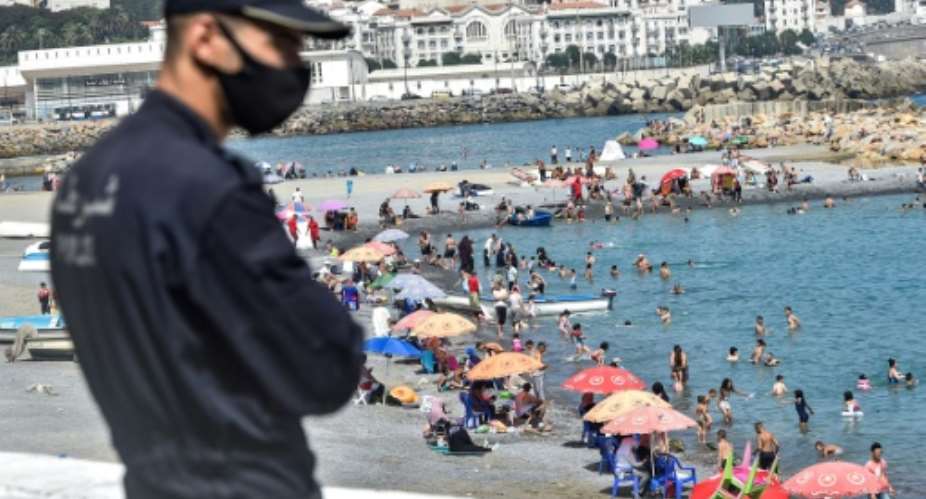 Algerians throng a beach in the Bab el-Oued suburb of the capital Algiers after authorities reopened beaches for the first time following a five-month coronavirus lockdown.  By RYAD KRAMDI AFP