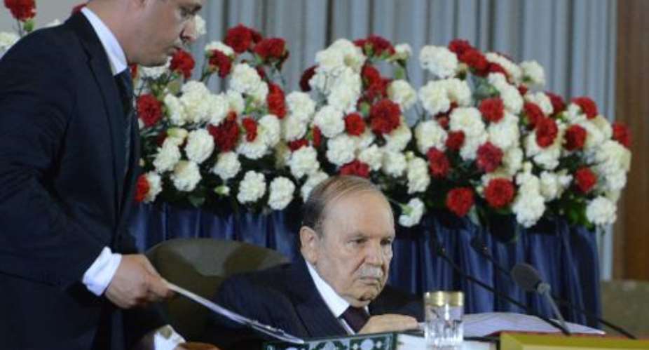 An officials hands Algerian President Abdelaziz Bouteflika documents during his inauguration ceremony as he is sworn in for a fourth term in Algiers on April 28, 2014.  By Farouk Batiche AFPFile