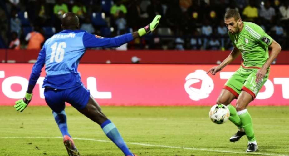 Algeria's forward Islam Slimani R controls the ball before scoring past Senegal's goalkeeper Khadim N'Diaye on January 23, 2017.  By KHALED DESOUKI AFP