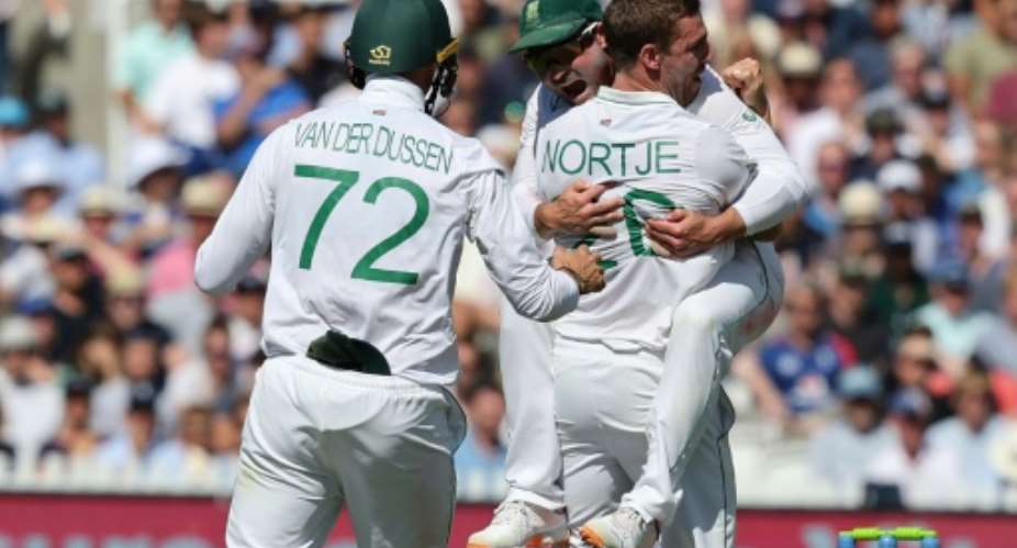 All together - South Africa's Anrich Nortje R celebrates with skipper Dean Elgar C after dismissing England's Alex Lees in the first Test at Lord's.  By Adrian DENNIS AFP