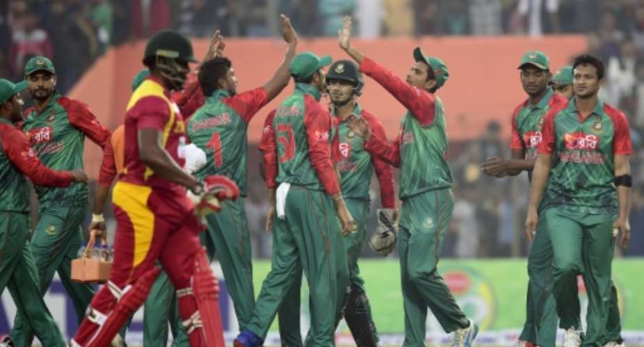 Bangladesh cricketers celebrate after the dismissal of the Zimbabwe captain Hamilton Masakadza 3L during the second T20 match at the Sheikh Abu Naser Stadium in Khulna on January 17, 2016.  By Munir Uz Zaman AFP
