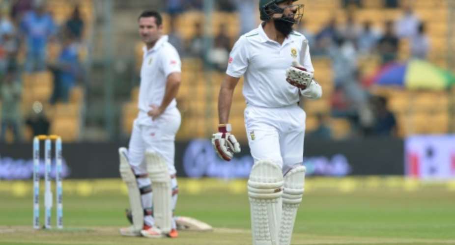 South Africa's Hashim Amla R walks back to the pavilion after losing his wicket for seven runs during the first day of the second Test against India in Bangalore on November 14, 2015.  By Manjunath Kiran AFPFile