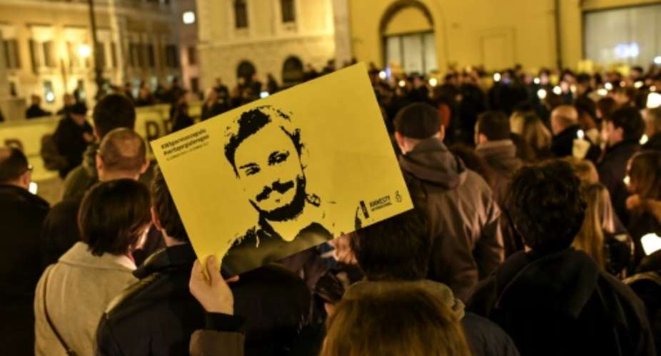 Amnesty International activists  hold a picture of student Giulio Regeni who was murdered in Egypt as they take part in a demonstration in front of the Italian Parliament in Rome in January 2017 a year after his killing.  By ANDREAS SOLARO AFPFile