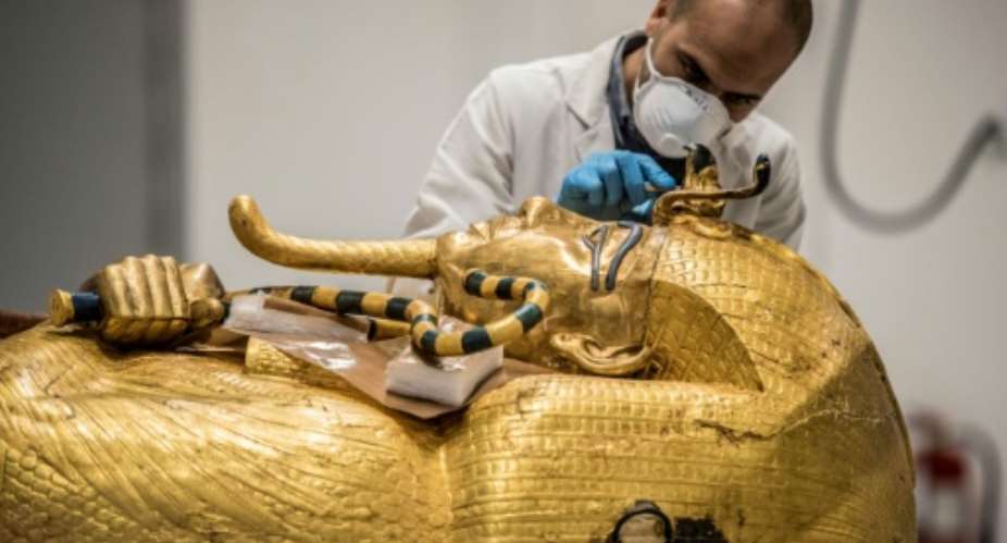 An archaeologist performs restorations on the sarcophagus of Pharaoh Tutankhamun in the restoration lab of the Grand Egyptian Museum in 2020.  By Khaled DESOUKI (AFP/File)