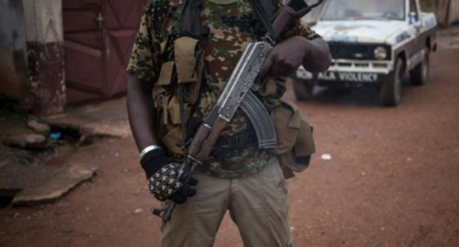 An armed militiaman stands guard at the entrance of the headquarters of a Muslim 'self-defence force' in Bangui.  By FLORENT VERGNES AFPFile