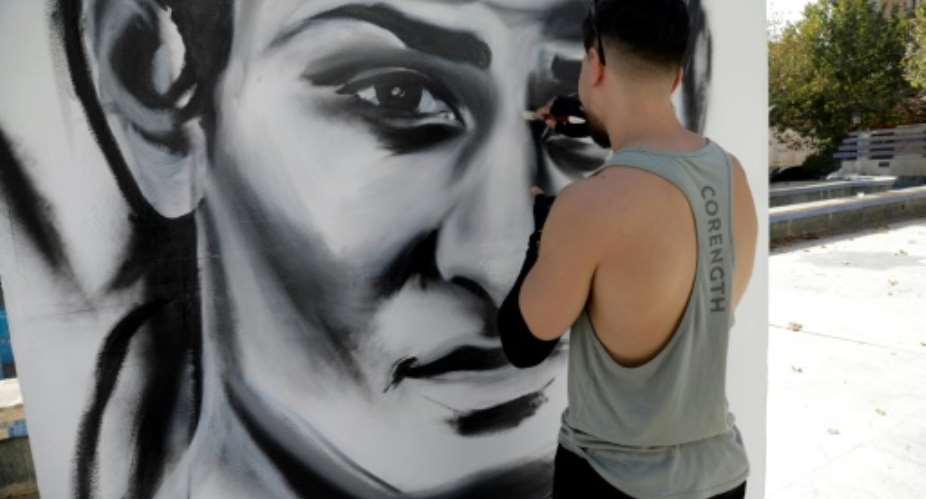 An artist paints a large portrait of Algerian Olympic boxing champion Imane Khelif in her hometown Tiaret.  By - (AFP)