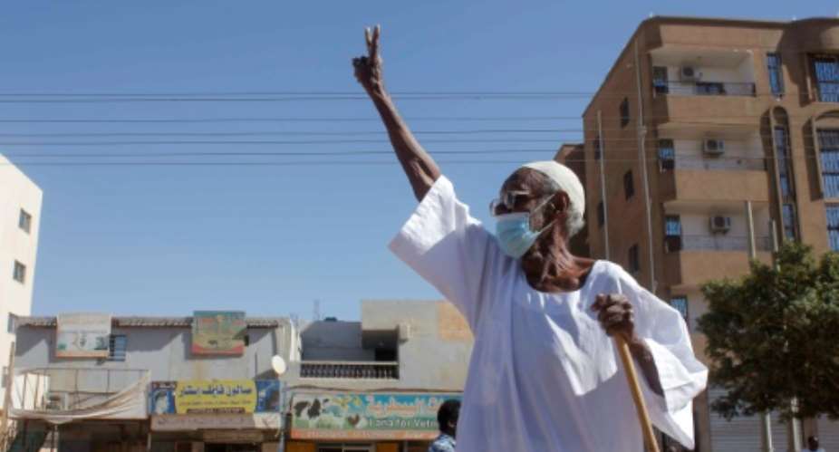 An elderly Sudanese man flashes the victory sign as protesters rally to call for a return to civilian rule in the capital Khartoum on November 21.  By - AFP