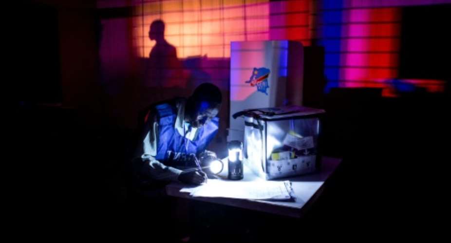 An electoral agent closes a voting station ahead of counting the ballots after the Democratic Republic of the Congos Presidential elections on December 30, 2018 in Kinshasa.  By JOHN WESSELS (AFP/File)
