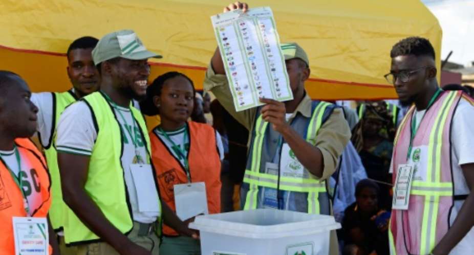 An electoral officer raises a ballot to count results after the Osun State gubernatorial election, which will go to a runoff in what is seen as a litmus test for President Buhari's popularity as he seeks a second term in February.  By PIUS UTOMI EKPEI AFP
