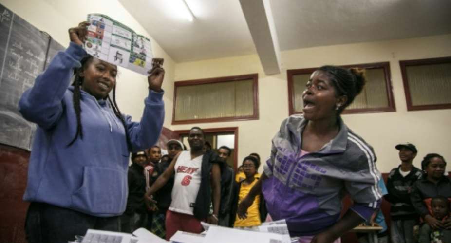 An electoral official holds up a ballot paper as votes are counted at a polling station in Antananarivo.  By RIJASOLO AFP
